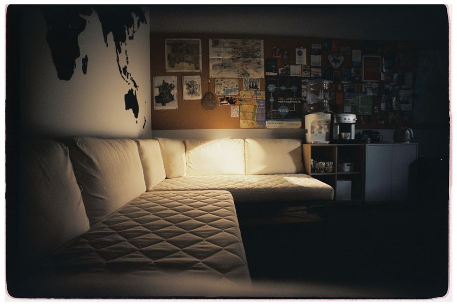 Inviting office lounge with a sectional sofa, world map art, and mood lighting.